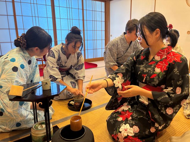 本学学生からお茶を点てる指導を受けている様子