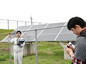 太陽光発電の説明を聞く学生達（空山にて）